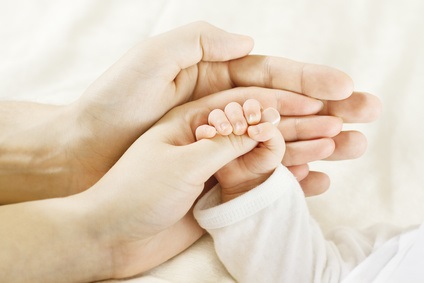 Closeup of baby  hand into parents hands. Family concept