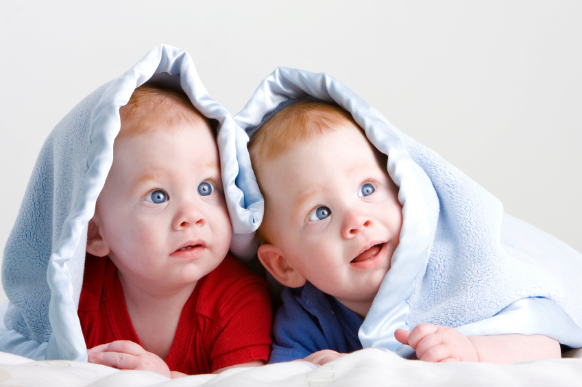 Beautiful redheaded twin babies under blanket